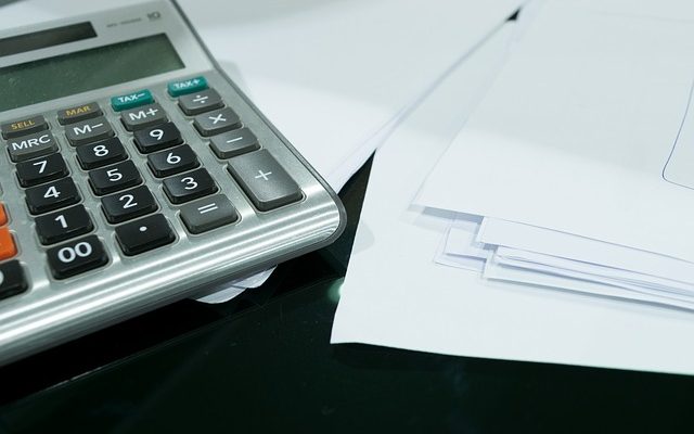 Imagem de uma calculadora e papéis sobre uma mesa ilustrando o que é faro contabil