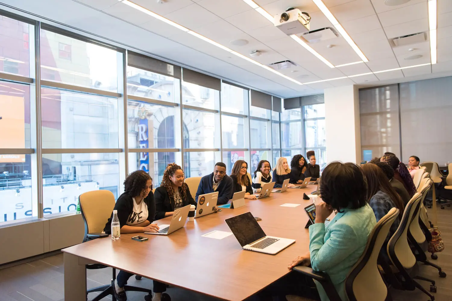 Ata de reunião empresarial com profissionais alinhando decisões estratégicas em ambiente corporativo com notebooks e mesa de conferência